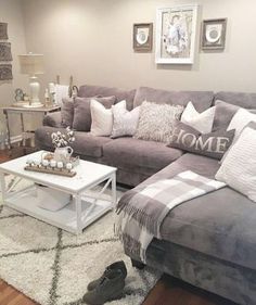 a living room with gray couches and white rugs on the floor next to a coffee table