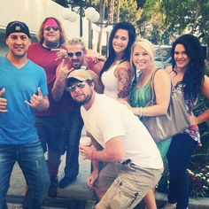 a group of people standing next to each other posing for the camera with their thumbs up