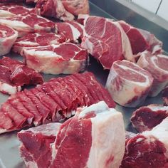 raw meats are lined up on a metal tray