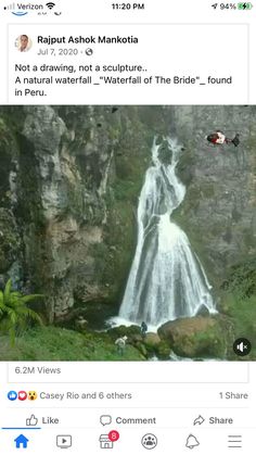 an image of a waterfall in the middle of a field with people standing near it