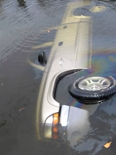 a car that is in some water with it's tire sticking out of the side