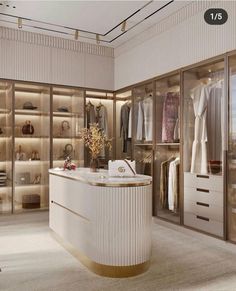 a walk - in closet with an oval counter and gold trim on the shelves, along with white drawers