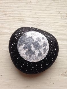 a black and white rock sitting on top of a wooden table