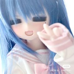 a doll with blue hair is holding her hand up