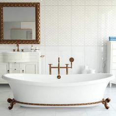 a white bath tub sitting on top of a tiled floor