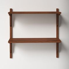 a wooden shelf on the wall with two shelves above it and one shelf below it