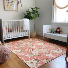 a baby's room with a pink rug and white crib