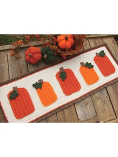 a crocheted table runner with pumpkins on it