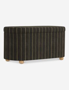 an upholstered bench with wooden legs and striped fabric