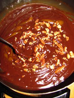 a pot filled with chocolate and nuts on top of a stove