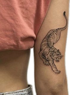 a woman's arm with a tiger tattoo on the left side of her body