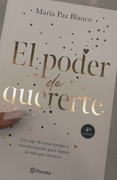 a person holding up a book with gold foil on it's cover and the title el poder de querete written in spanish