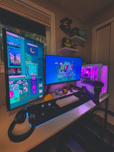 two computer monitors sitting next to each other on top of a white desk in front of a window