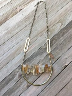 Fabulous! This delicate yet substantial stick bead bar necklace is done in genuine semi-precious citrine stones. These sparkly gold stones are so beautiful and they are shimmery in the light. This stone is so unique and beautiful. The chain has a few funky brass shapes and is attached to the bar on wire. Below it is a gold metal U that seems to be holding the bar in place.  There is a matching pair of earrings available: https://etsy.me/2Td9toT My jewelry is all handmade, so no two pieces will e Artisan Brass Necklaces With Natural Stones, Gold Artisan Multi-stone Necklace, Vintage Brass Necklace With Natural Stones, Gold Multi-strand Crystal Necklaces With Natural Stones, Gemstone Bar Necklace, Bead Bar Necklace, Stone Bar, Bead Bar, Stone Beaded Necklace