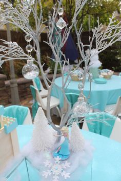 an image of a frozen birthday party with trees and snowflakes on the table