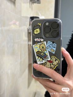 someone holding up their phone case with stickers on it