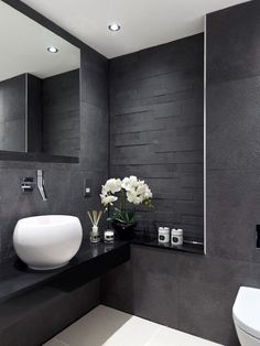 a white sink sitting under a bathroom mirror next to a wall mounted faucet