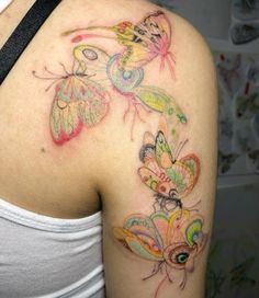 a woman's shoulder with colorful butterflies on it