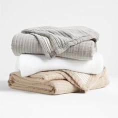 three folded blankets stacked on top of each other