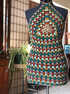 a crocheted apron sitting on top of a mannequin