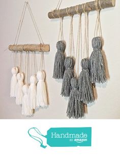 three macrame hangings with tassels attached to each other on a wall