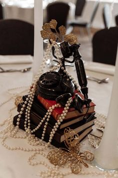 a stack of books sitting on top of a table next to a white candle holder