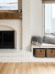 a living room with a fire place next to a window and a painting on the wall