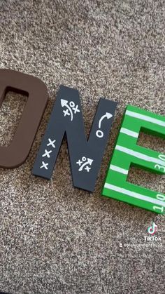 the letters are made out of wood and painted with black, white and green paint