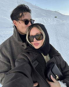 a man and woman taking a selfie in the snow