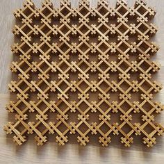 wooden lattices are arranged in the shape of an intricate pattern on a wood floor