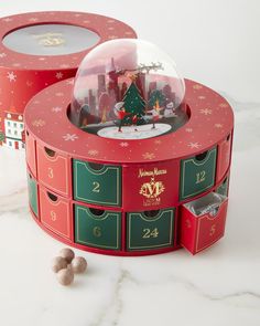 two red boxes with christmas decorations inside on a white surface next to some balls and snowflakes