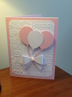 a pink and white birthday card with balloons