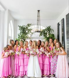 a group of women standing next to each other in front of a chandelier