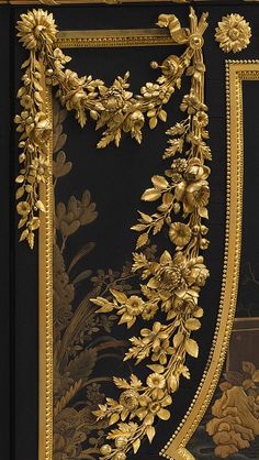 an ornate gold leaf and flower design on black fabric with golden trimmings,