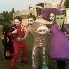 three people in halloween costumes posing for the camera