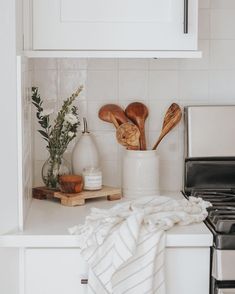 a kitchen counter with utensils on it and a towel draped over the stove