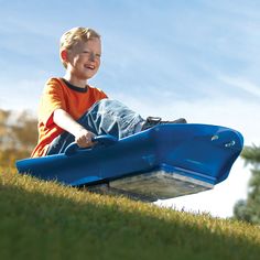 a young boy sitting on top of a blue toy airplane