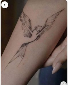 a woman's arm with a bird tattoo on it