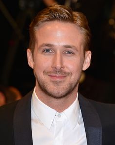 a close up of a person wearing a suit and tie with a smile on his face