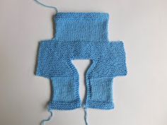 a blue knitted object on a white surface