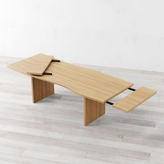 a wooden table sitting on top of a hard wood floor next to a white wall