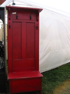 a red wooden bench sitting next to a white tent