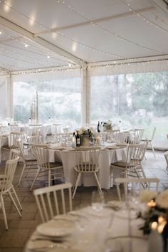 a room filled with tables and chairs covered in white tablecloths