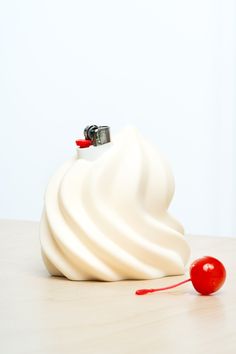 a whipped cream container with a cherry on the side and a white wall in the background