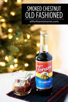 a bottle of liquor sitting on top of a table next to a glass filled with liquid