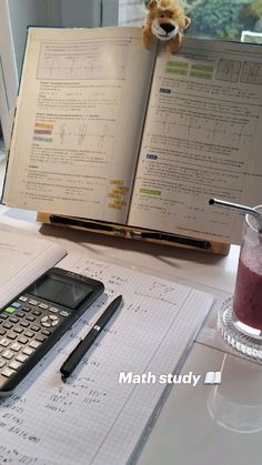 a calculator sitting on top of a table next to an open book