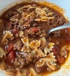 a white bowl filled with pasta and meat