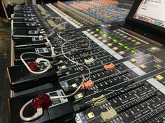 an electronic mixing console with many knobs and wires