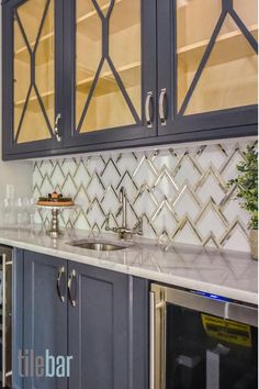 a kitchen with blue cabinets and white marble counter tops, stainless steel appliances and glass doors