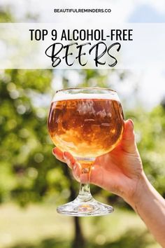 a person holding up a wine glass with the words top 9 alcohol - free beers